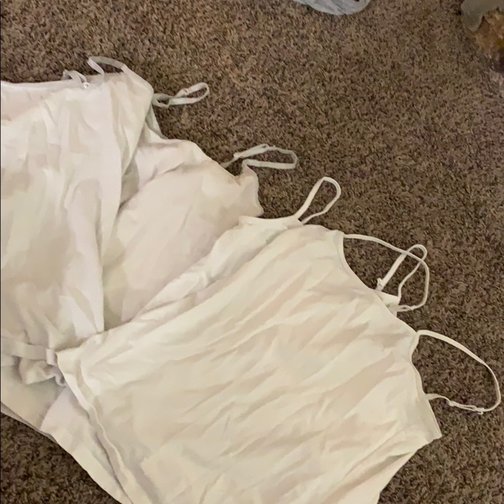 Four white tank tops